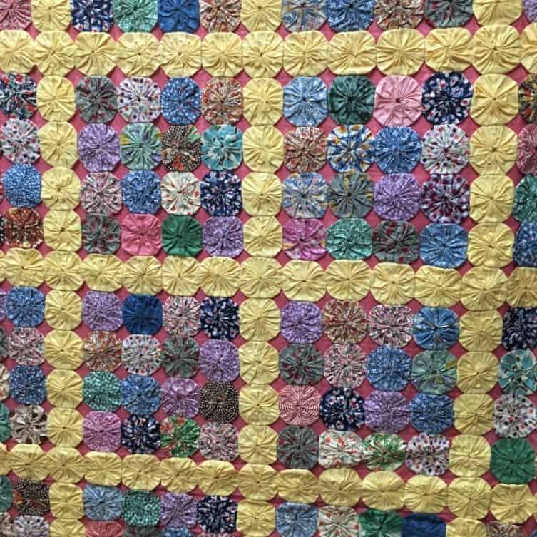 Borders of yellow add interest to this Yo-Yo quilt.