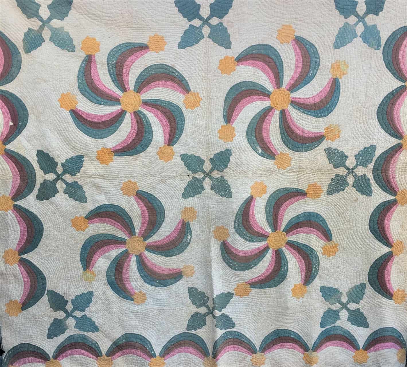 This lively pattern features applique pinwheel-type patterns with leaves and a scalloped frame.